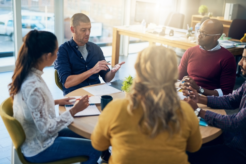 Réunion d’équipe illustrant le management participatif et syndicats dans l’entreprise, avec échanges entre salariés et encadrement autour d’une table de travail.
